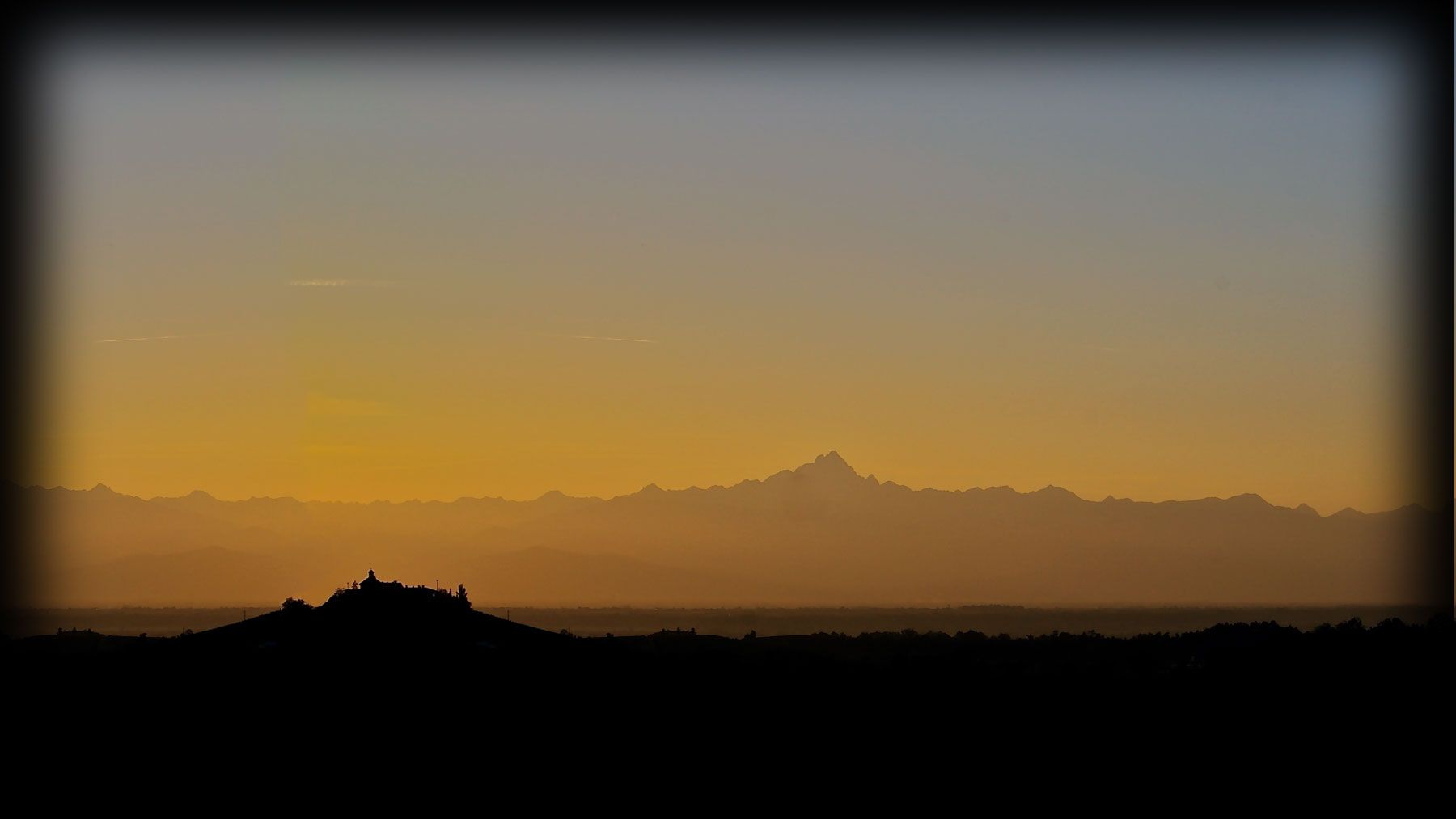 Le Alpi al tramonto e la collina con la cappella, viste da Dogliani